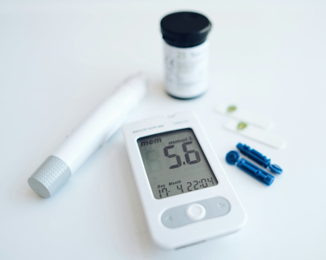A blood glucose meter with a lancing device and test strips on white